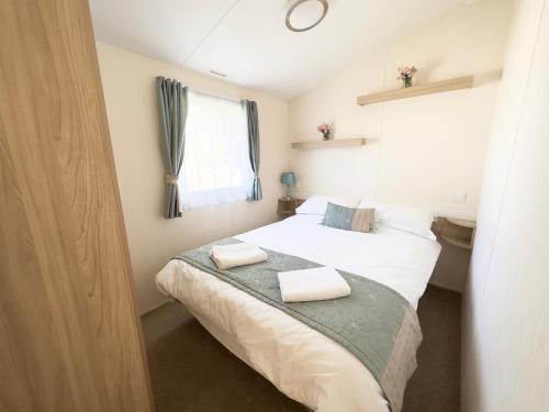 a bedroom with a bed with two towels on it at Edinburgh - Seton Sands-Salsa Caravan-Pet Friendly in Port Seton