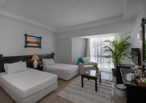 uma sala de estar com uma cama e um sofá em Olives at Santa Monica em Marsa Matruh