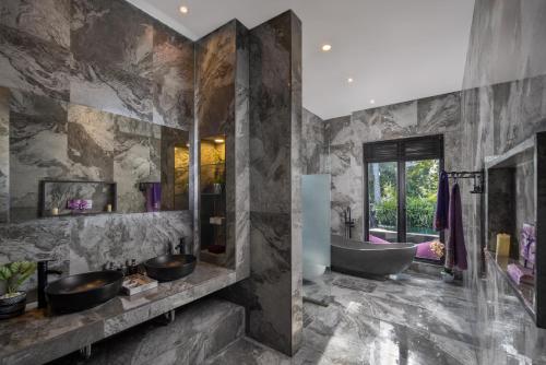 a bathroom with two sinks and a bath tub at Capung Asri Eco Luxury Resort with Private Pool Villas in Bedahulu