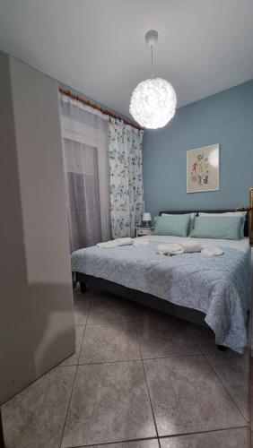 a bedroom with a bed and a blue wall at Tilemachos central apartment in Alexandroupoli