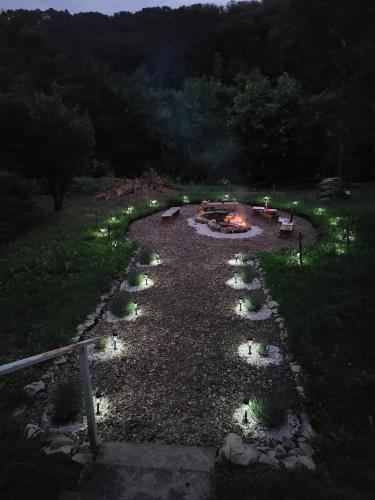 una hoguera con luces en un patio por la noche en Mészi Vendégház en Zalacsány