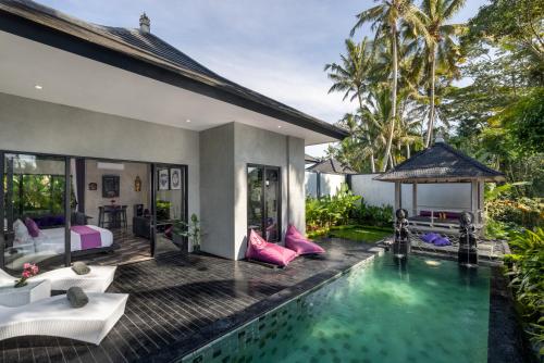 a villa with a swimming pool and a bedroom at Capung Asri Eco Luxury Resort with Private Pool Villas in Bedahulu