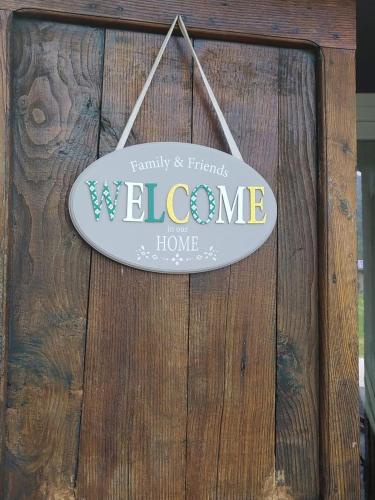 a welcome sign hanging on a wooden wall at PANORAMIC GREEN VALLEY in Sulzano