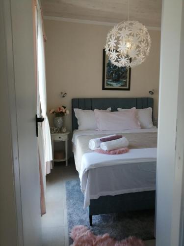 a bedroom with a bed and a chandelier at Luxury Apartment Slavica in Vodice