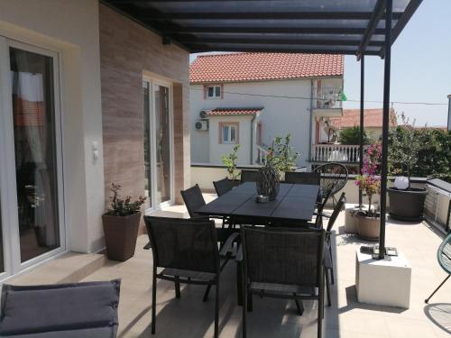 patio con mesa y sillas en el balcón en Luxury Apartment Slavica, en Vodice