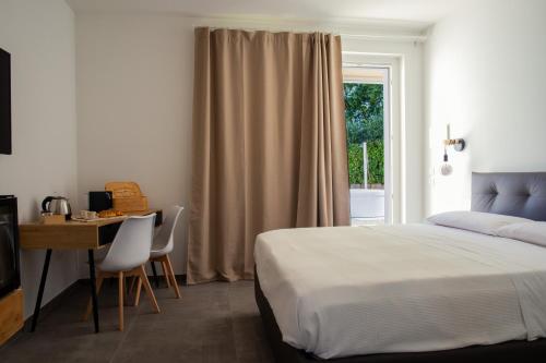 Schlafzimmer mit einem Bett, einem Schreibtisch und einem Fenster in der Unterkunft Ulivo Bianco in San Giovanni Teatino