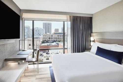 AC Hotel by Marriott San Diego Downtown Gaslamp Quarter في سان دييغو: غرفة فندقية بسرير ونافذة كبيرة