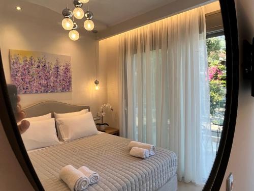 a bedroom with a bed and a large window at Maison deluxe studios and apartment in Parga