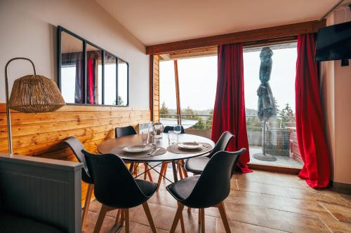 jadalnia ze stołem i krzesłami oraz oknem w obiekcie Mystic Mountain Apartment Chamrousse w mieście Chamrousse
