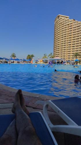 a man laying on a beach chair next to the water at Regency Porto pyramids in Ain Sokhna