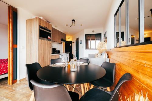 ein Esszimmer mit einem schwarzen Tisch und Stühlen in der Unterkunft Mystic Mountain Apartment Chamrousse in Chamrousse