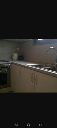 a kitchen with a sink and a stove and a counter at Villa tolis in Mádhena