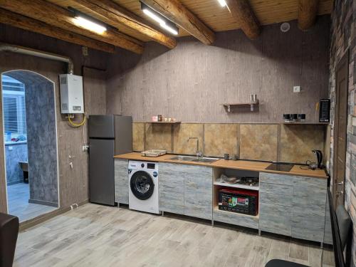 een keuken met een wastafel en een wasmachine bij Sundukyan Apartments in Gjoemri