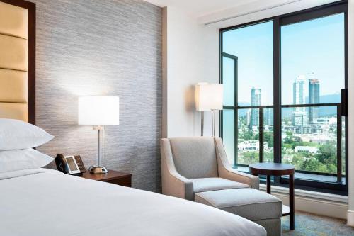 a hotel room with a bed and a chair and a window at Delta Hotels by Marriott Burnaby Conference Centre in Burnaby