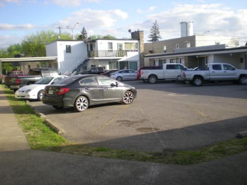 a group of cars parked in a parking lot at Motel Seigneurie de Vaudreuil in Vaudreuil-Dorion