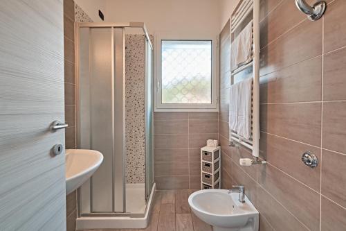 een badkamer met een wastafel, een toilet en een raam bij Hotel Astoria in Bordighera
