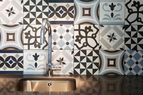 a bathroom with a sink and a tile wall at Apartment Vila Olímpica Barcelona next to beach & garden in Barcelona
