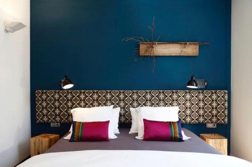 una camera da letto con parete blu e un letto con cuscini di Apartment Vila Olímpica Barcelona next to beach & garden a Barcellona