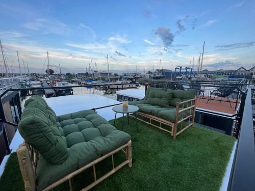 two couches and a table on top of a boat at Cosy tiny houseboats near beach and restaurants by Weltevreden Experience in Zeewolde