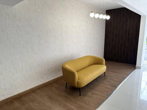 a yellow chair in a room with a wall at Premium space in Santiago- 5 Min Away from airport in Santiago de los Caballeros