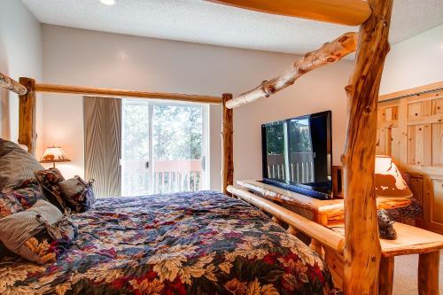 um quarto com uma cama de madeira e uma televisão em Stunning Multi-Level Home near Hiking Trails and Main St, with PRIVATE Hot Tub WP33 em Breckenridge