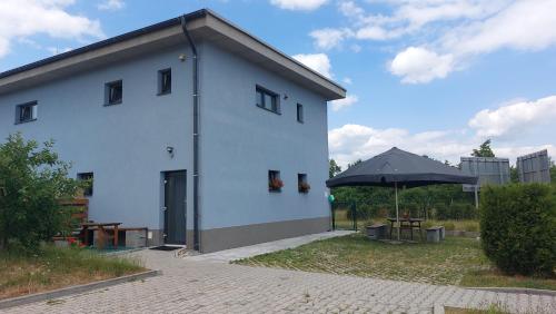 a white building with an umbrella next to a table at Penzion u vody in Plzeň