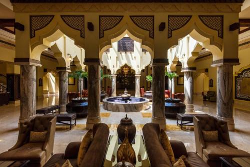 Sharq Village & Spa, a Ritz-Carlton Hotel في الدوحة: لوبي فيه نافورة في وسط المبنى