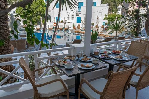 een tafel met eten op een balkon met uitzicht op een zwembad bij Hotel Matina in Kamari