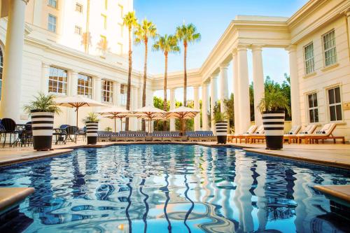 una piscina di fronte a un edificio con palme di Southern Sun The Cullinan a Città del Capo