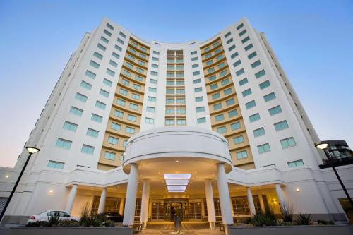 a large white hotel building with a dom at Southern Sun Waterfront Cape Town in Cape Town