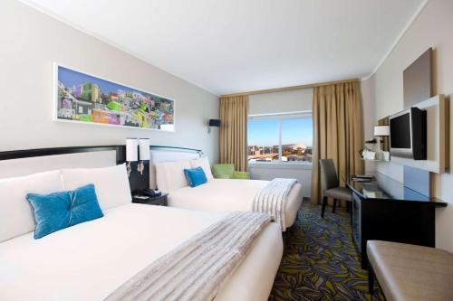 a hotel room with two beds and a television at Southern Sun Waterfront Cape Town in Cape Town