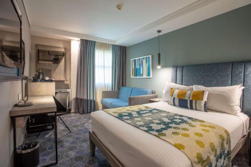una camera d'albergo con letto e scrivania di StayEasy Mbombela a Nelspruit