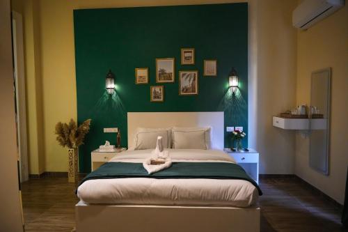 a bedroom with a large bed with a green wall at Hathor House in Cairo