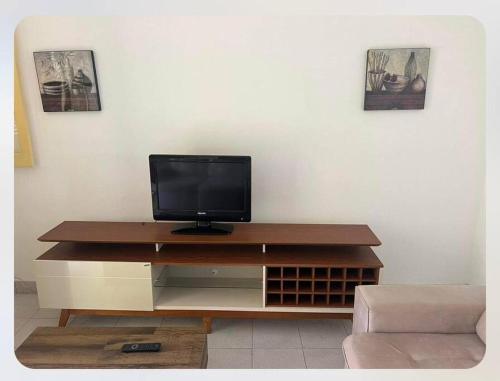 a television sitting on top of a wooden entertainment center at Apartamento Vista Mar in São Tomé