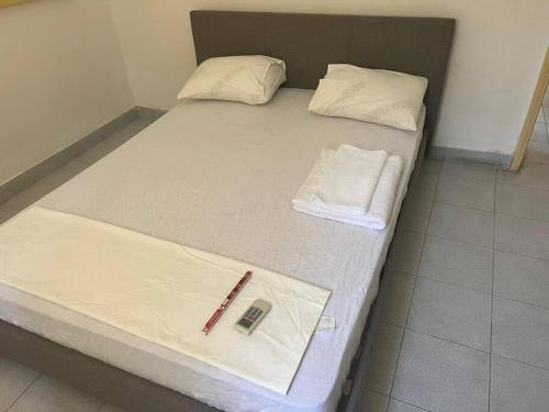 a bed with a remote control on top of it at Apartamento Vista Mar in São Tomé