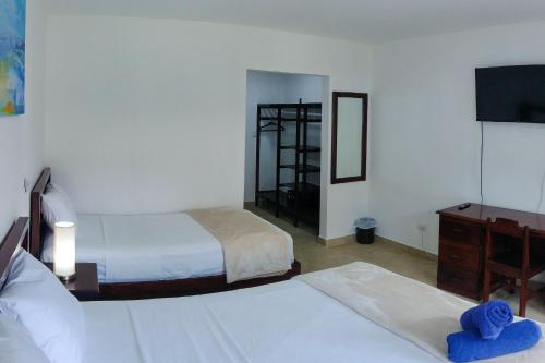 a hotel room with two beds and a television at Fuego del Sol Beachfront Hotel in Jacó