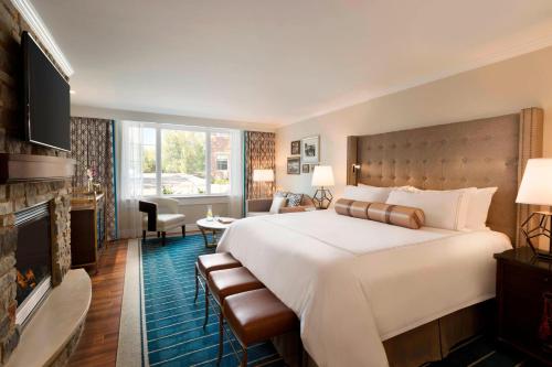 アマーストにあるReikart House Buffalo, a Tribute Portfolio Hotelの大きなベッドとリビングルームが備わるホテルルームです。