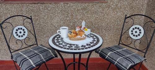 a table with a plate of food on it with two chairs at CASA OLGUITA in Godoy Cruz