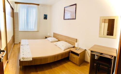 a small bedroom with a bed and a mirror at Apartment Marina Senj in Senj