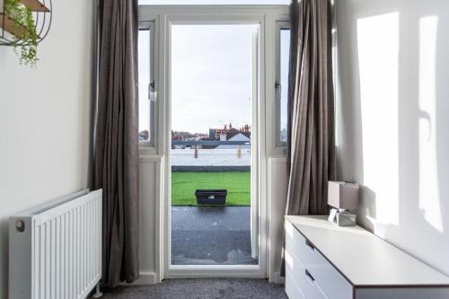 a room with a door open to a view of the water at 2 bed apartment near the beach in Southend-on-Sea