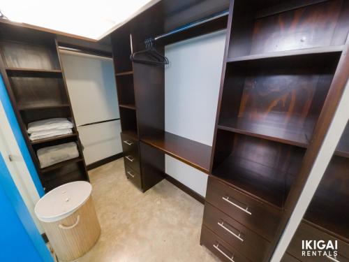 a closet with wooden shelves and a toilet in it at Jm House in Alajuela City