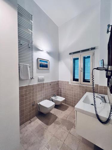 a bathroom with a toilet and a tub and a sink at Best Stay - Intendenza21 in Bari