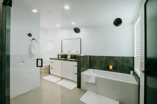uma casa de banho com uma banheira, um lavatório e um espelho. em Coyote Tracks - A Modern Desert Experience em Joshua Tree