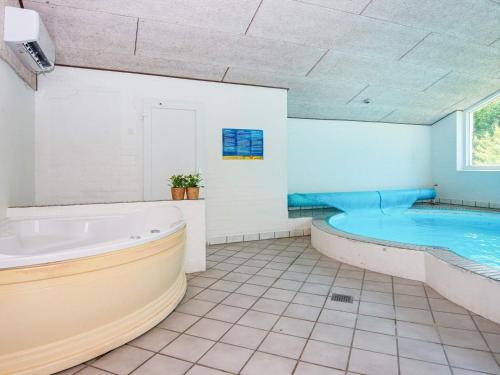 a large bathroom with a tub and a swimming pool at 14 person holiday home in rsted in Kare