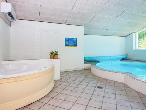 baño grande con bañera y piscina en 14 person holiday home in rsted, en Kare