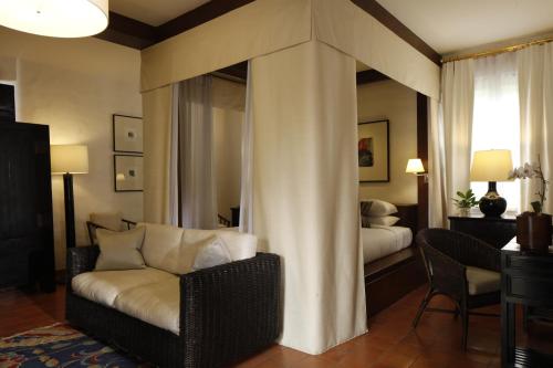 a living room with a couch and a bedroom at Rachamankha Hotel in Chiang Mai