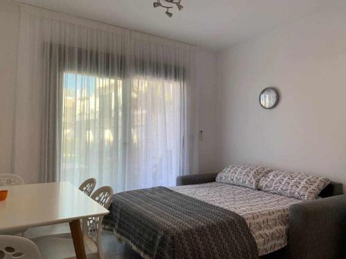 - une chambre avec un lit, une table et une fenêtre dans l'établissement Hermoso estudio en Pilar de la Horadada, à Pilar de la Horadada