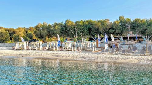 a group of chairs and tables on a beach at Thassos Hotel Grand Beach in Limenaria