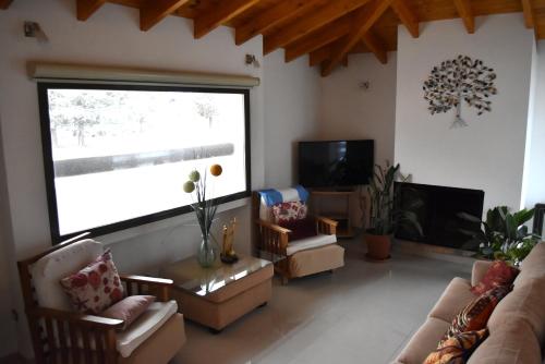 a living room with couches and a large window at Refugio Andino in Malargüe