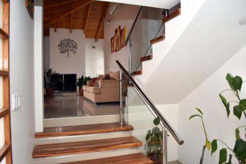 a staircase in a home with white walls and wood floors at Refugio Andino in Malargüe